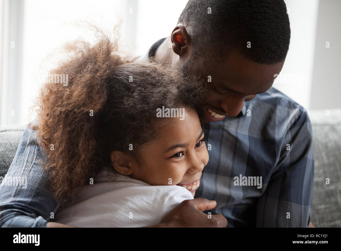 Süße kleine Mixed-race girl Umarmung liebevolle afrikanische Papa zu Hause Stockfoto