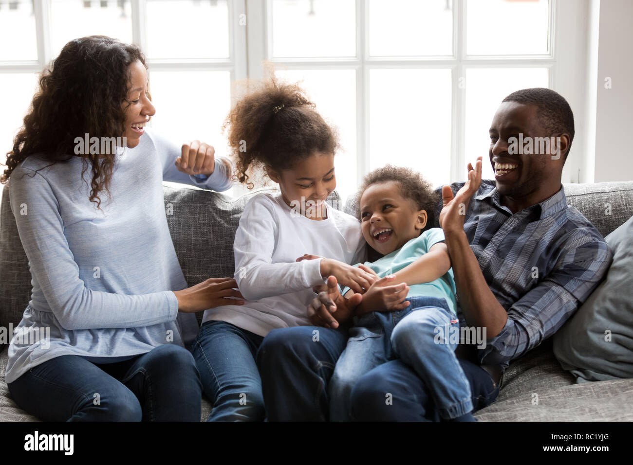 Gerne schwarze Familie lachen Spielen kitzeln Kinder zu Hause Stockfoto