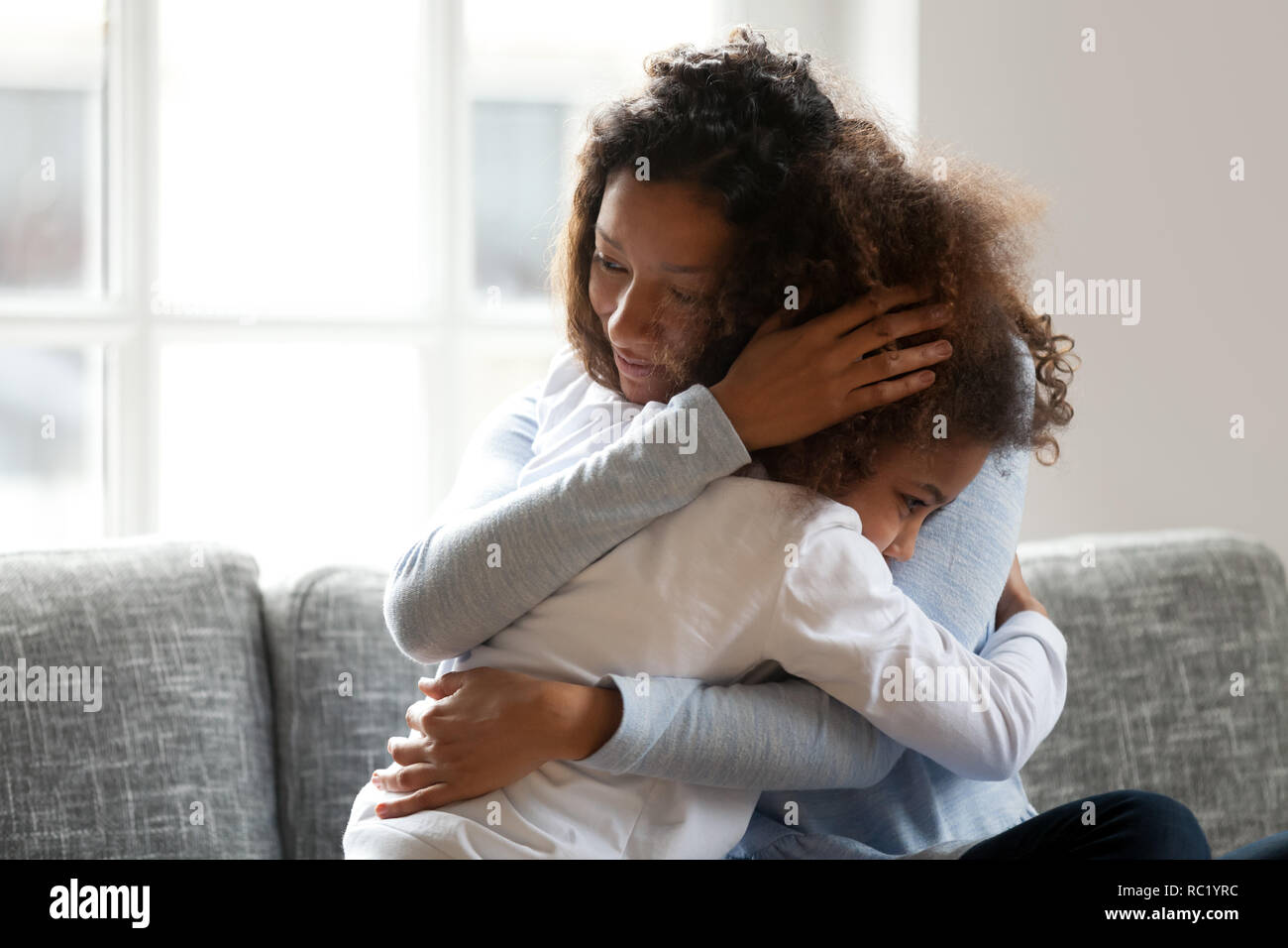 Liebevolle einzelne schwarze Mutter umarmt afrikanischen Tochter streicheln Cu Stockfoto