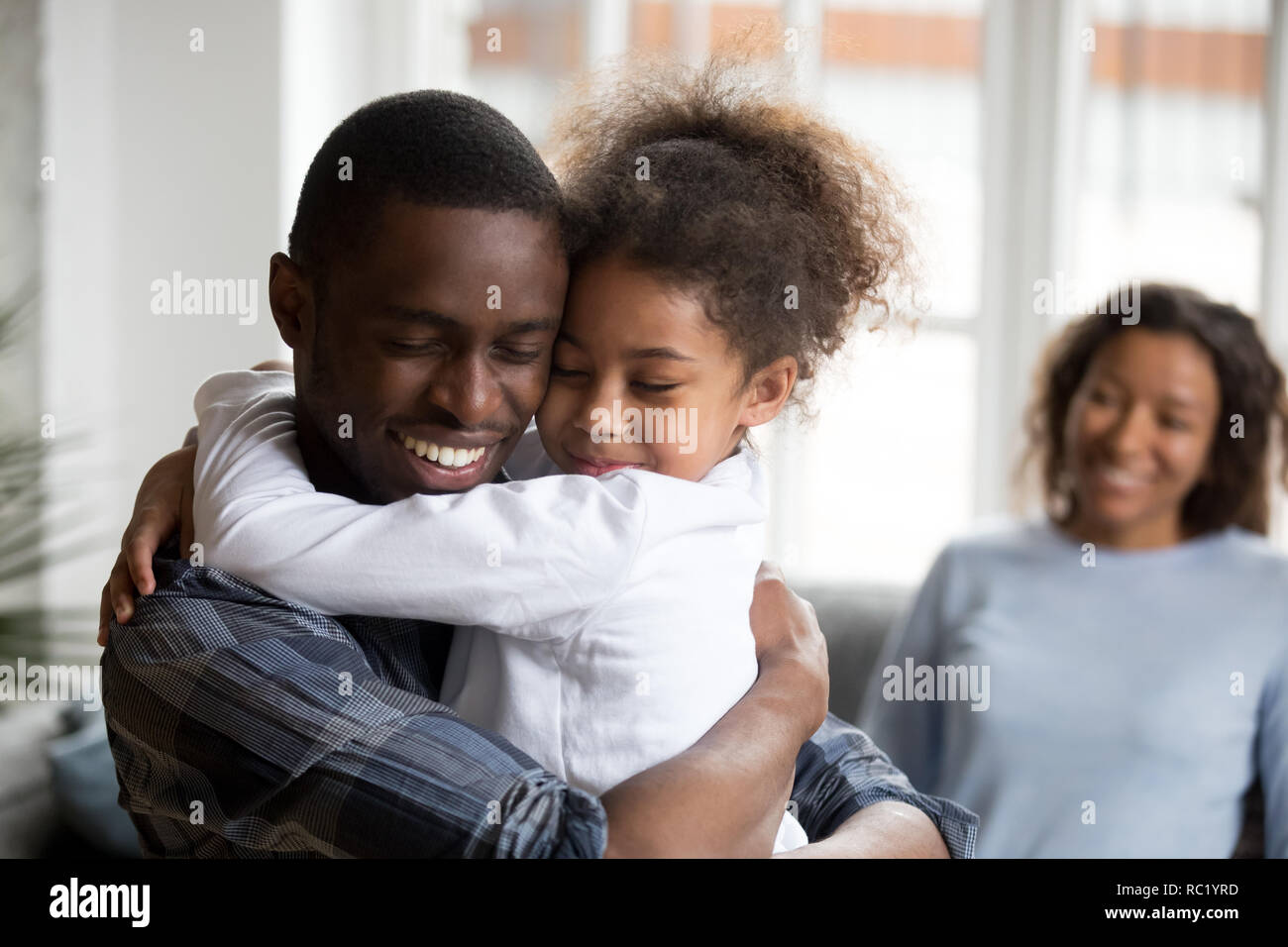 Süße kleine schwarze Mädchen umarmt glücklich African American Dad Stockfoto