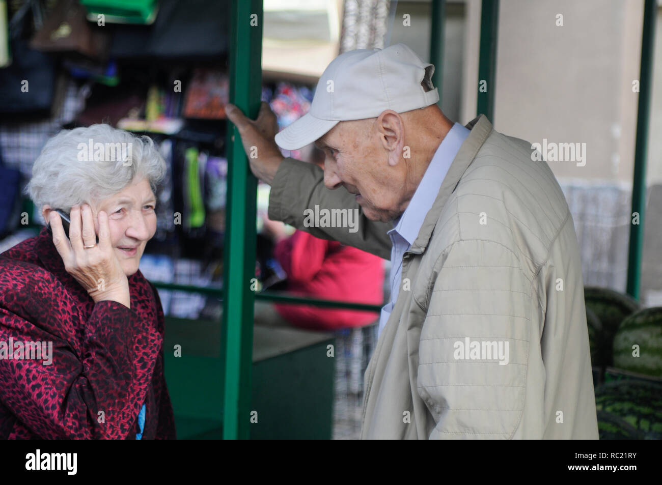 Ältere Paare mit der Frau, die in der Rede auf dem Mobiltelefon, Lettland Stockfoto