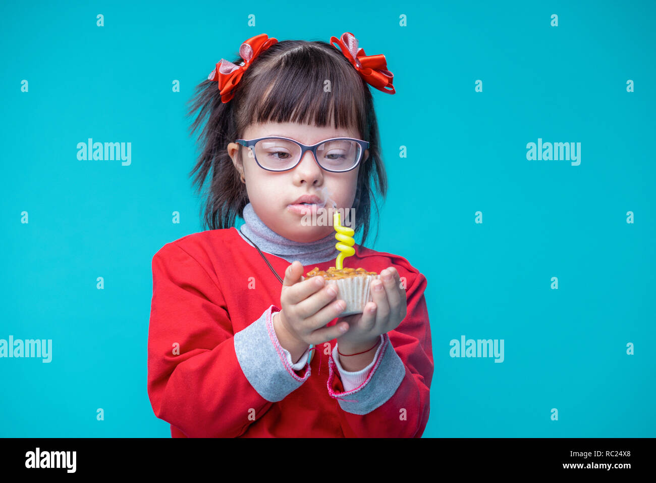 Neugierig, hübsche kleine Dame mit genetischen Störung Löschanlage funky Kerze Stockfoto