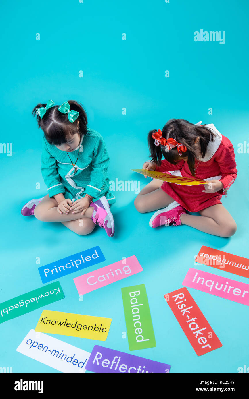 Mädchen mit Haar Schwänze aufmerksam lesen Worte auf bunten Namensschilder Stockfoto