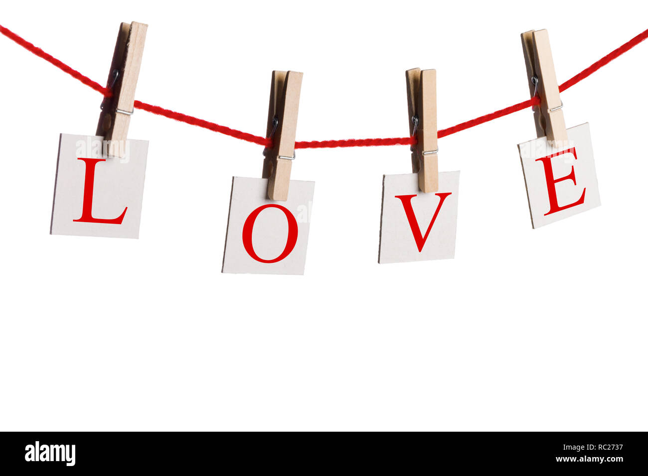 Wäscheklammern und Wort LIEBE auf Papieren am Seil auf weißem Hintergrund Valentines Tag Konzept Stockfoto