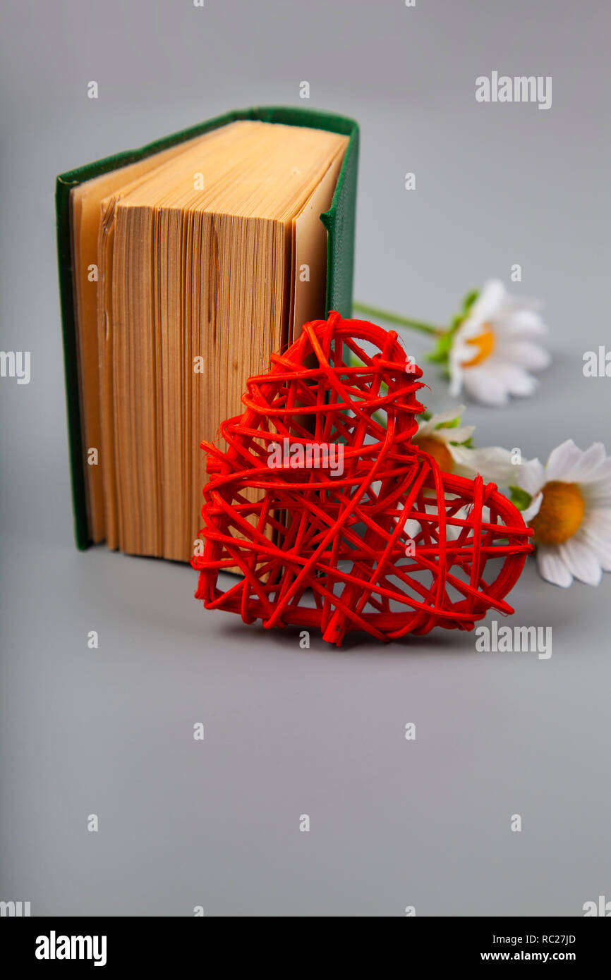 Buchen Sie mit romantischen Gedichten, Blumen und einem Herz. Geschenk für den Valentinstag. Stockfoto