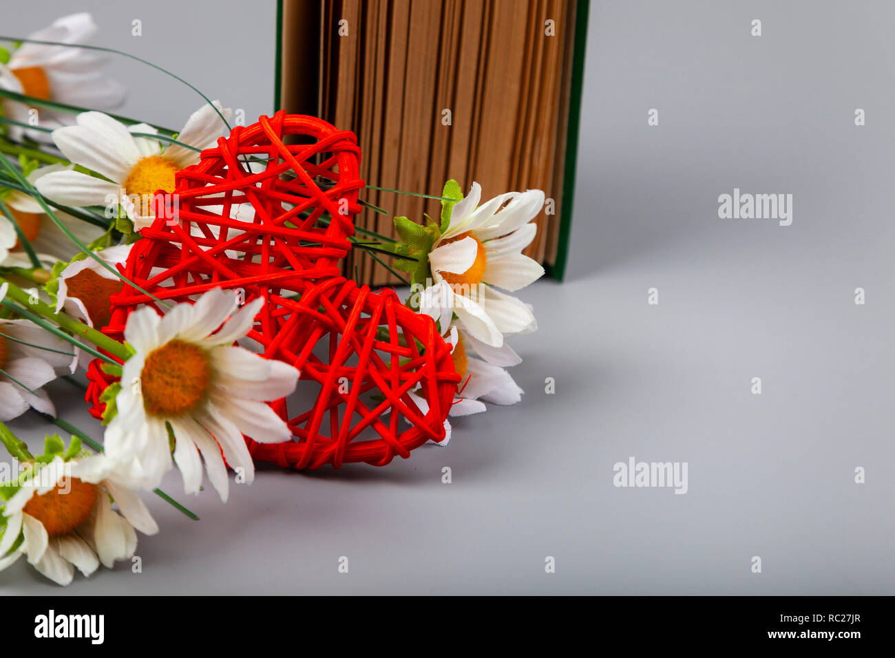 Buchen Sie mit romantischen Gedichten, Blumen und einem Herz. Geschenk für den Valentinstag. Stockfoto