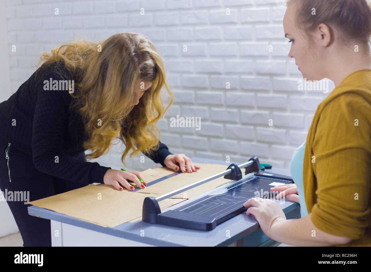 Zwei professionelle Frauen Dekorateure, Designer arbeiten mit Kraftpapier in Werkstatt, Studio. Basteln, Dekoration und Kunst Konzept Stockfoto