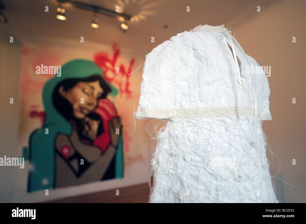 Ein Kleid von Veronica Buchanan und ein Wandbild von der brasilianischen Graffiti Künstler Brutto, während eine Vorschau der Aufenthalt mit mir zeigen, durch die Tuam Mutter und Baby zu Hause Skandal inspiriert, Im Turm Galerie in Dublin. Stockfoto
