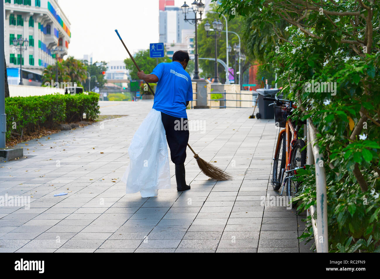Singapur - Jan 15, 2017: Arbeiter Reinigung der Straße in Singapur. Singapur ist ein globaler Handel, Finanzen und Transport Hub Stockfoto