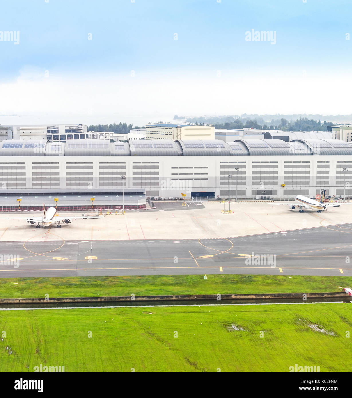 Ansicht von Flugzeugen, die in der Start- und Landebahn von grünen Rasen, Singapur Stockfoto