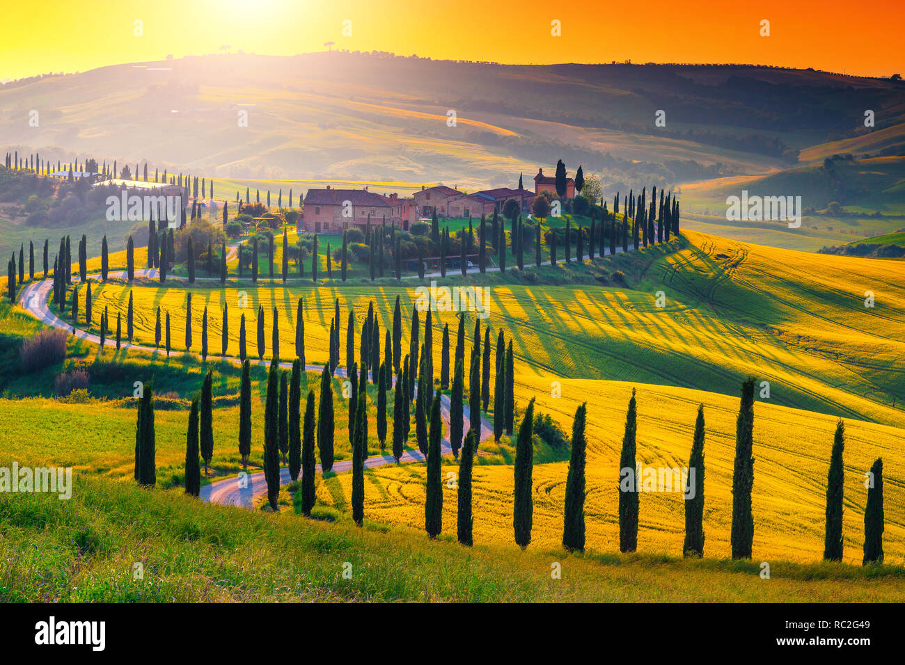 Berühmte beliebte Reise und Fotografie statt. Majestic bunten Sonnenuntergang und landwirtschaftlichen Bereich mit typischen Toskana Häuser aus Stein auf dem Hügel, in der Nähe von Siena Stockfoto
