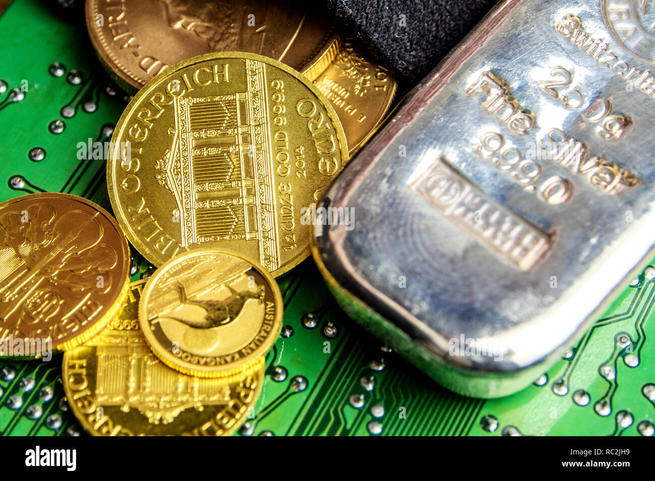 Nahaufnahme des goldenen Münzen und Silber Ziegelstein mit einem Data Processor, elektronische Computer Hardware Technologie und ihre Oberfläche mit grünem Hintergrund Stockfoto