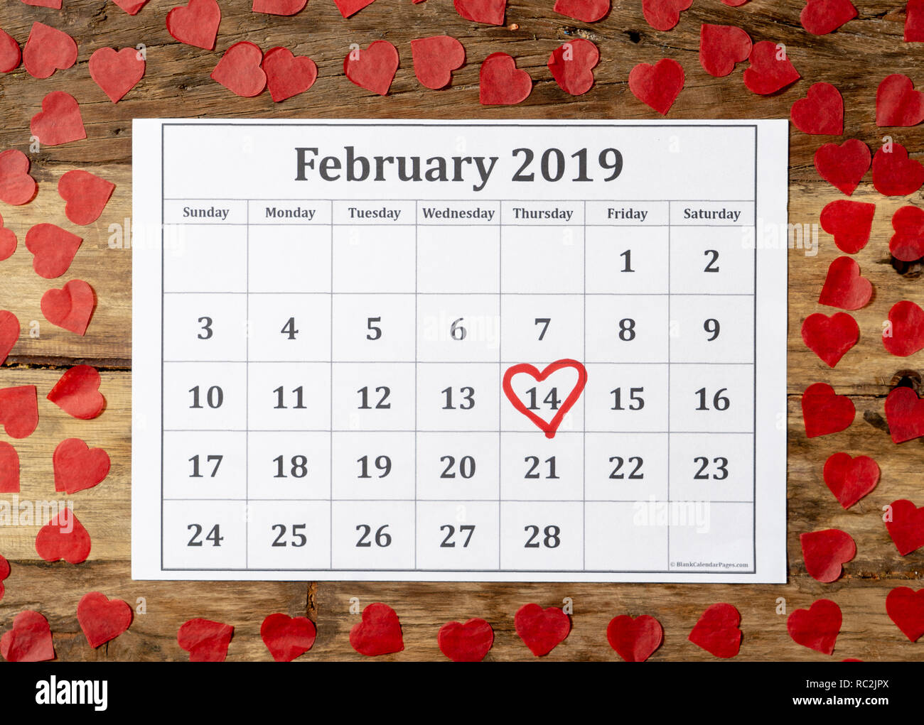 Kalender Seite mit roten Herzen am 14. Februar von Saint Valentines Tag auf vintage Tisch mit Herz in der romantischen Liebe Feier und Valentine' gerahmt Stockfoto