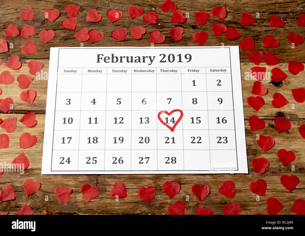 Kalender Seite mit roten Herzen am 14. Februar von Saint Valentines Tag auf vintage Tisch mit Herz in der romantischen Liebe Feier und Valentine' gerahmt Stockfoto