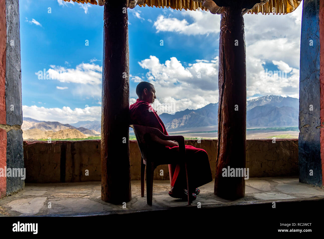 Thikse, Indien - August 16, 2015: Ein buddhistischer Mönch mit rotem Gewand auf einem Stuhl ruht in Thikse Gompa (Kloster) Stockfoto