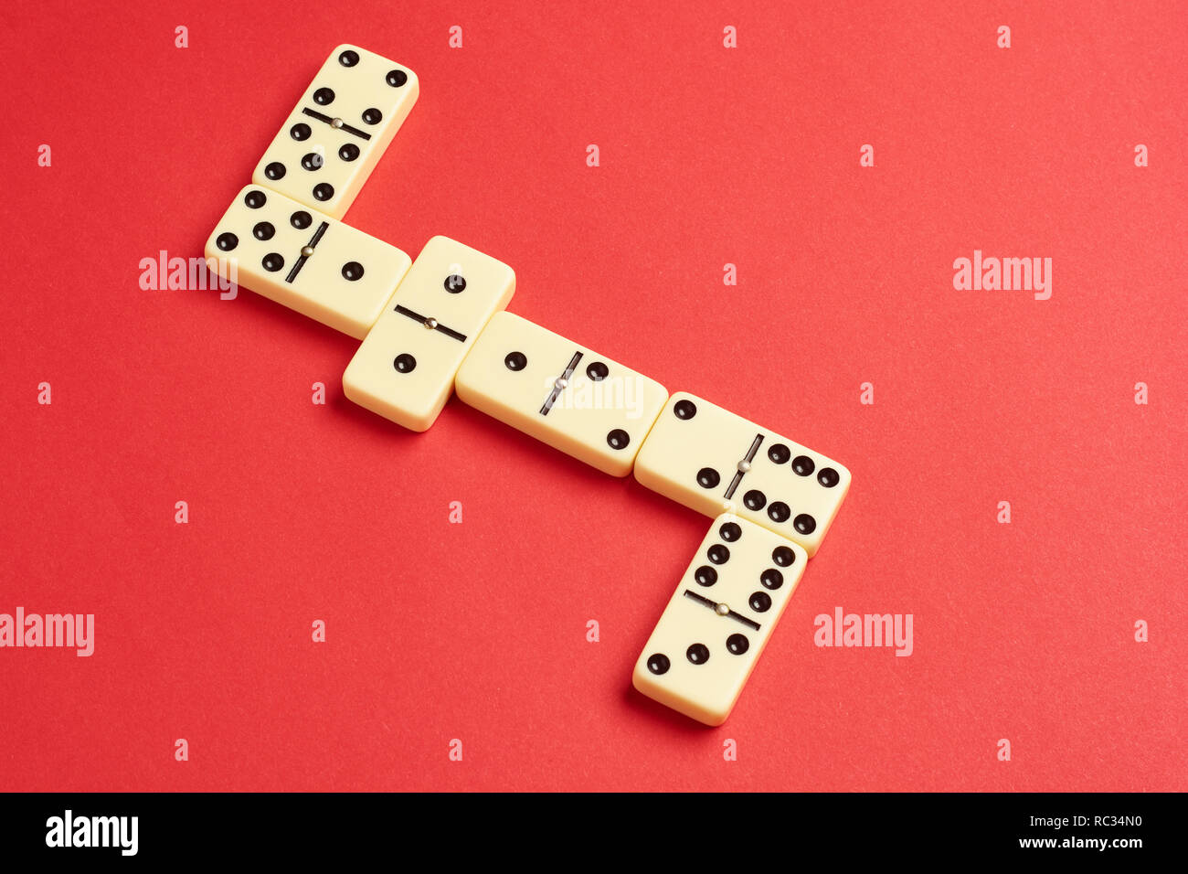 Flach Konzept. Gesellschaftsspiele Publikationen. Domino Stücke auf dem roten Hintergrund mit kopieren. Stockfoto