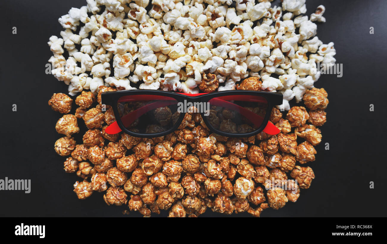 Abstraktes Bild von Viewer, 3D-Brillen und Popcorn auf schwarzem Hintergrund Stockfoto