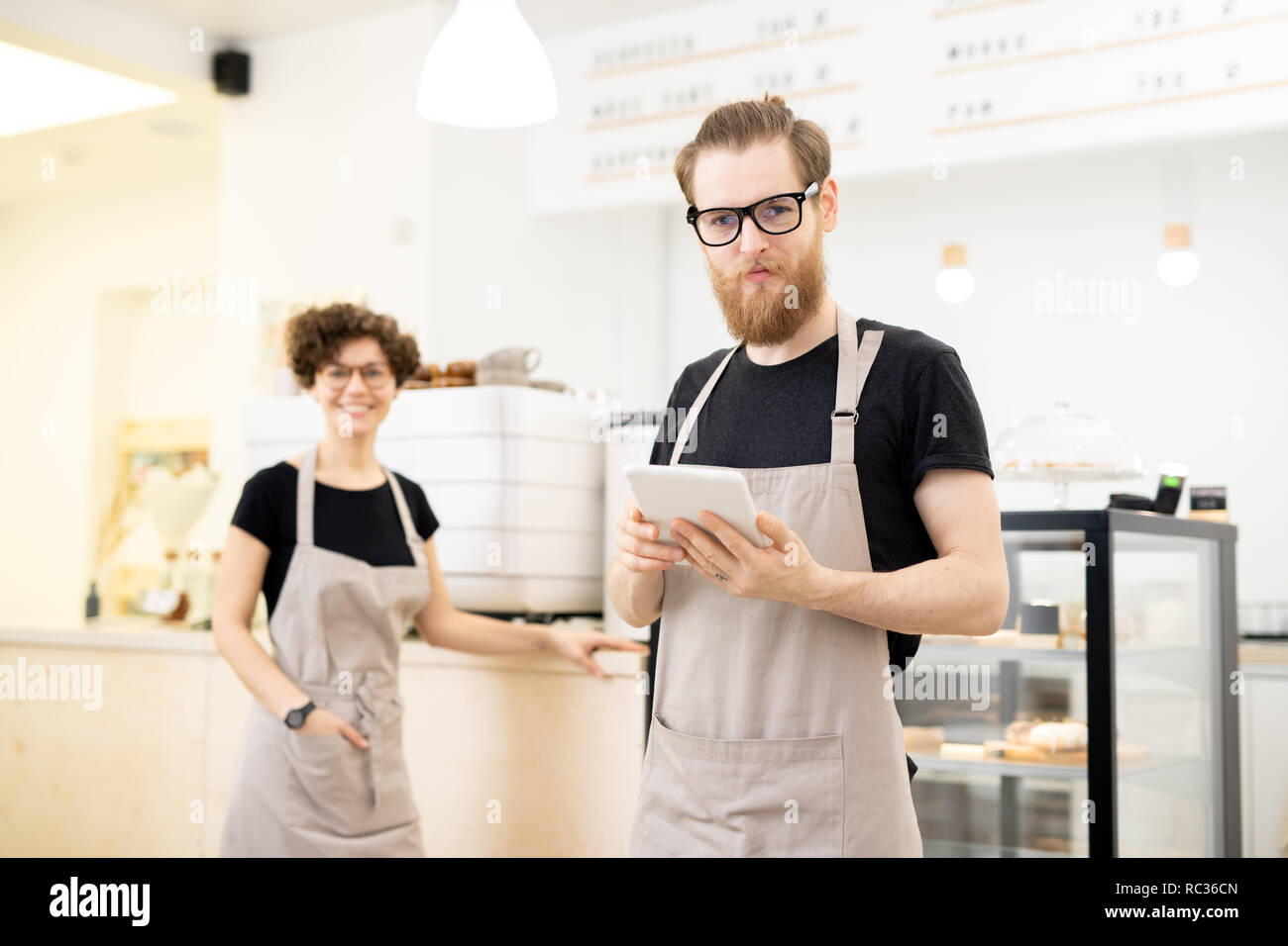 Inhalt junger Kellner im Café Stockfoto