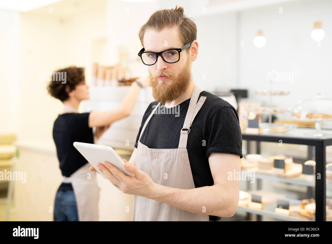 Ernsthafte hipster junger Kellner im Cafe Stockfoto