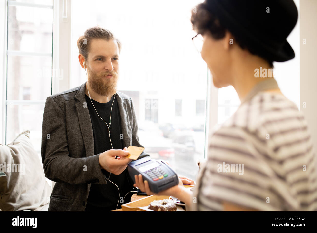 Zufriedene Menschen zahlen für Rechnung im Cafe Stockfoto