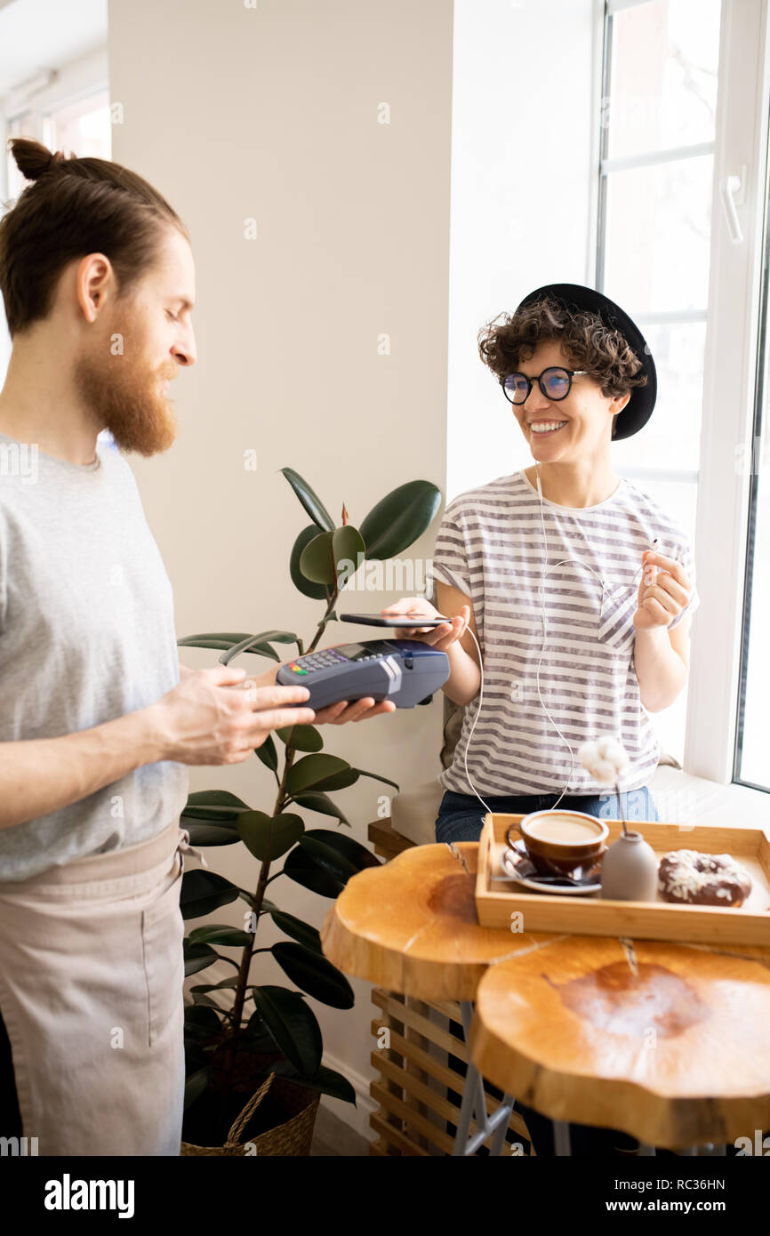 Bezahlen mit Gadgets im Coffee Shop Stockfoto