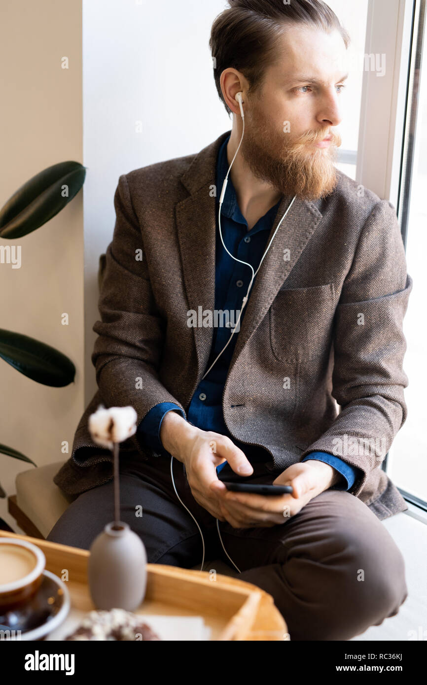 Die introspektive hipster Mann hören die Musik im Kopfhörer. Stockfoto