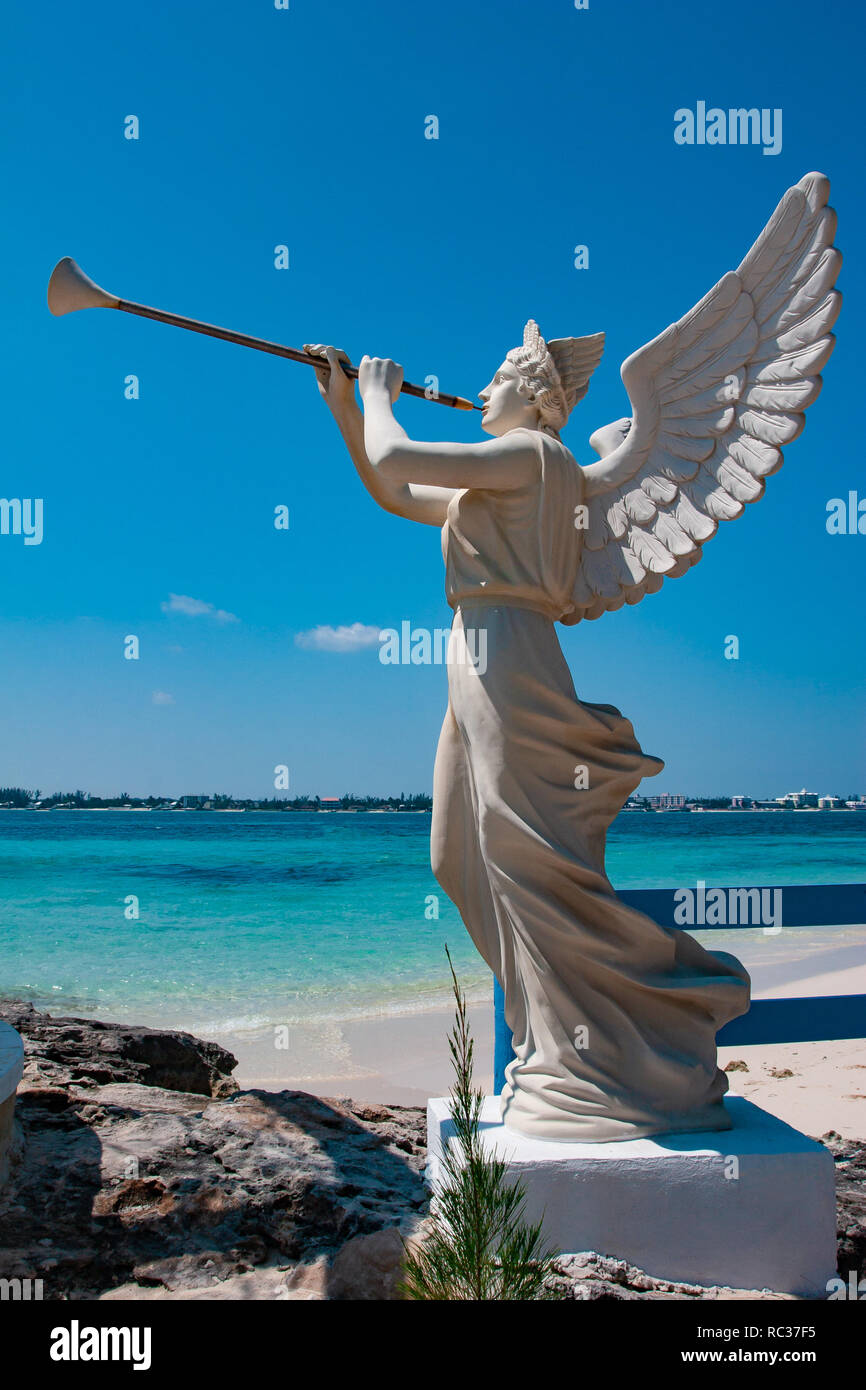 White Skulptur eines Engels holding Trompete mit den blauen Himmel im Hintergrund, im Freien, sonnigen Tag. Stockfoto
