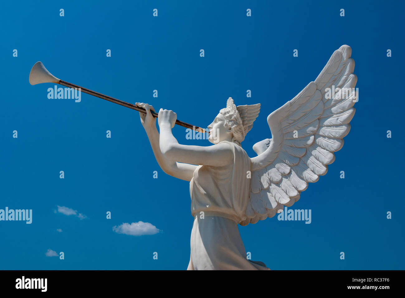White Skulptur eines Engels holding Trompete mit den blauen Himmel im Hintergrund, im Freien, sonnigen Tag. Stockfoto