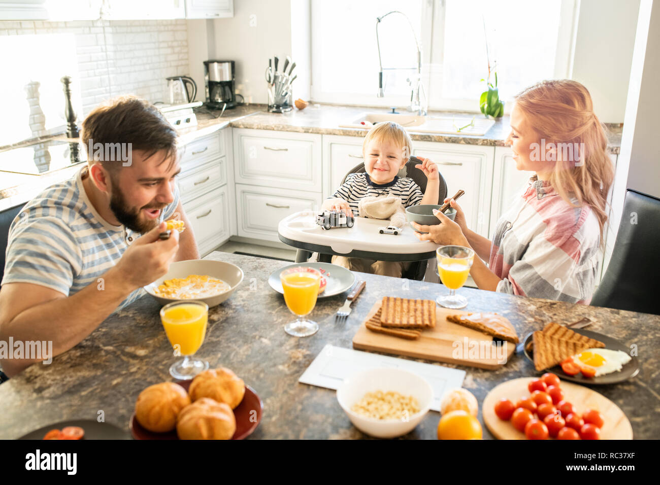 Glückliche Familie am Küchentisch in Morgen Stockfoto