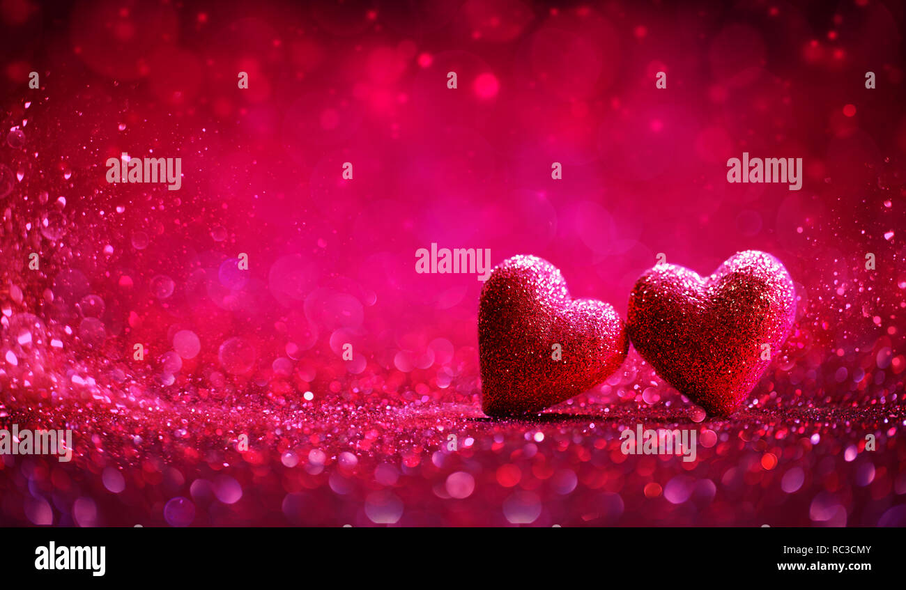 Zwei rote Herzen in glänzendem Hintergrund - Valentinstag Stockfoto