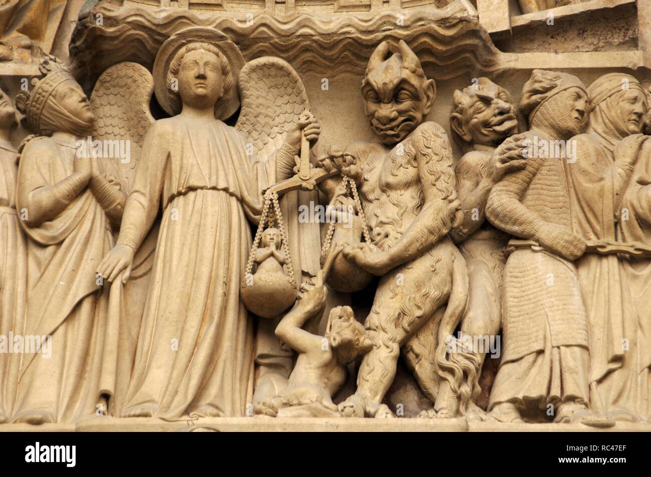 Gotische Kunst in Frankreich. Paris. Notre Dame. Skulpturen verziert das Portal des Jüngsten Gerichts. Es wurde in den 1220s-1230 s gebaut. Fassade. Der Erzengel Michael ist ihre Seelen wiegen mit einem pelzigen Devil Interferenzen. Paris. Stockfoto