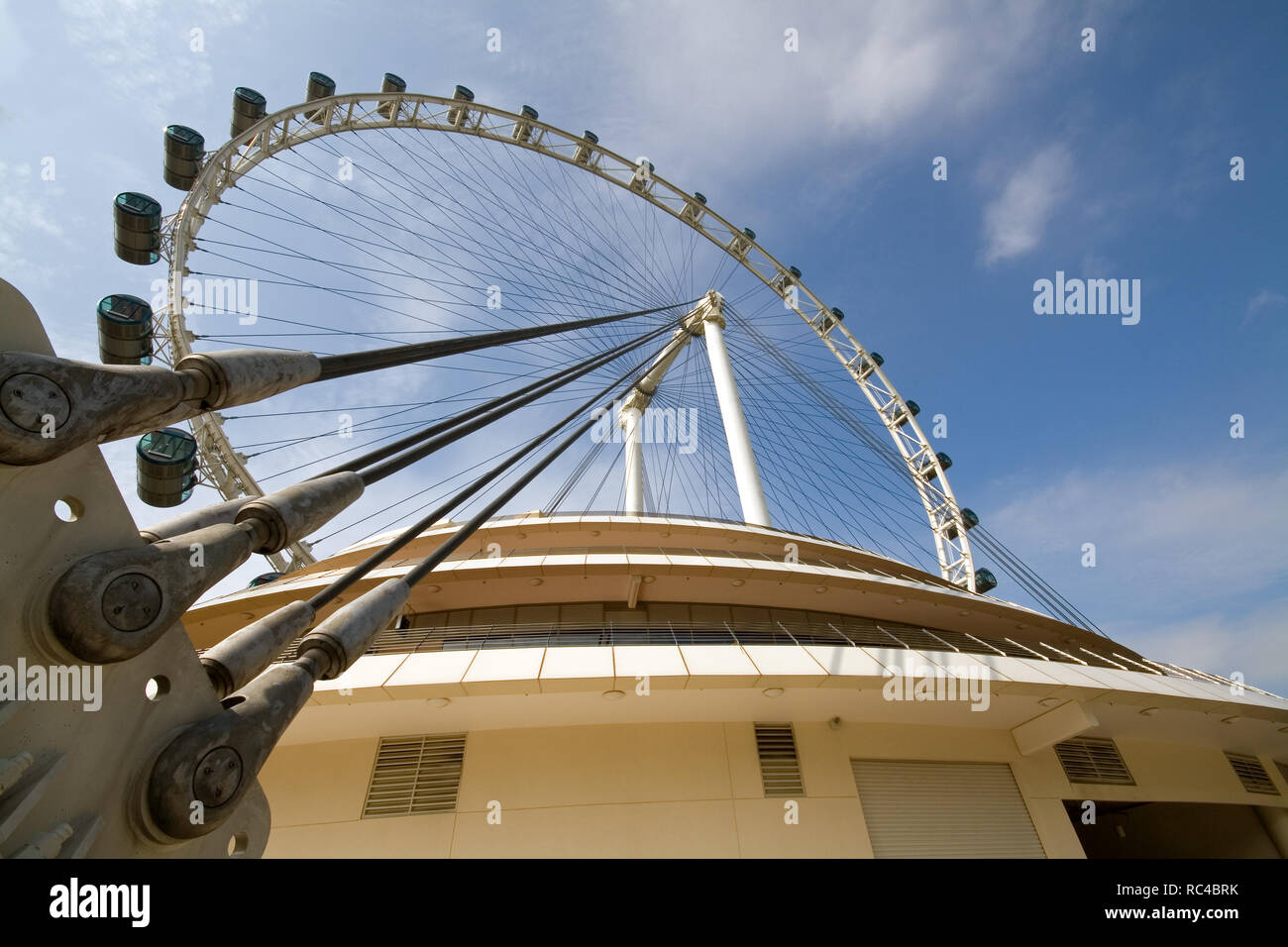 Singapore Flyer, ein gigantisches Riesenrad in Singapur, einst der größte mit einer Höhe von 165 Meter, gesehen von unten an einem sonnigen Tag. Stockfoto