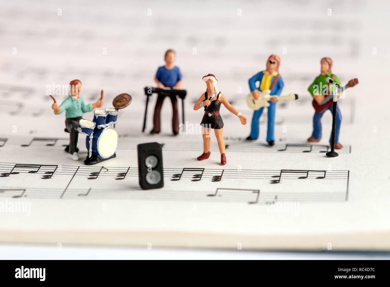 Rock Band miniatur Menschen auf der Open Music Buch mit Noten, der Neigung gesehen - Verschiebung selektiv konzentrieren, von hohen Winkel Stockfoto