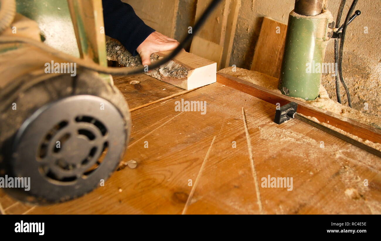 Handwerker verwendet eine Kreissäge einen Schnitt zu einem Stück von rauhen Holz in seiner eigenen Werkstatt zu machen Stockfoto