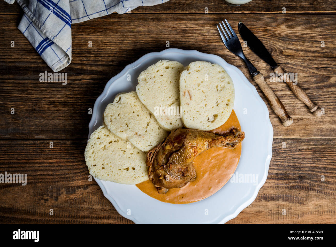 Traditionelle tschechische Küche Hähnchen Schenkel auf Red Pepper Sauce mit Knödeln auf Holz Tisch Stockfoto
