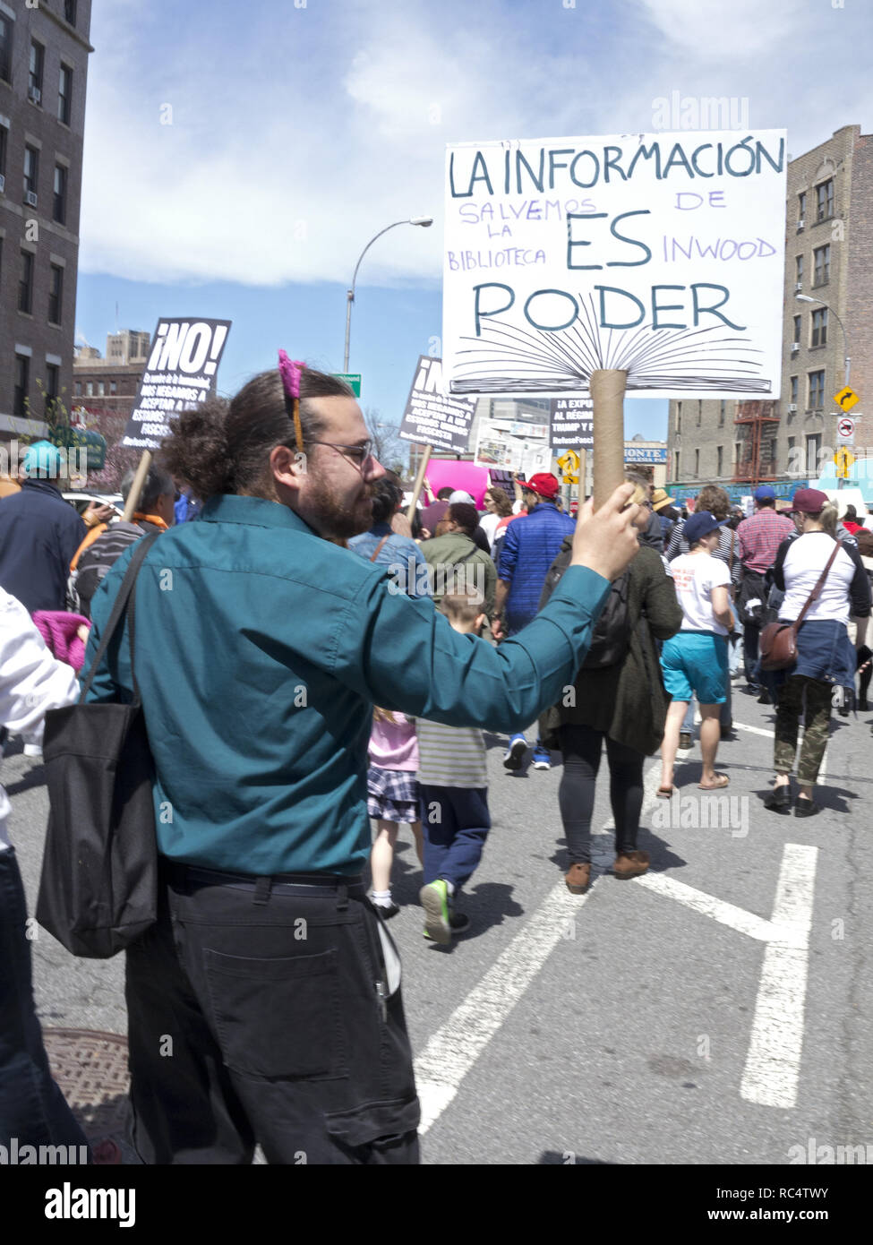 Hunderte von Demonstranten versammelten sich in Harlem zu sammeln und in der Uptown März für Einwanderer, 2017 März. Mann hält 'Speichern Inwood Bibliotheken" zu unterzeichnen. Stockfoto