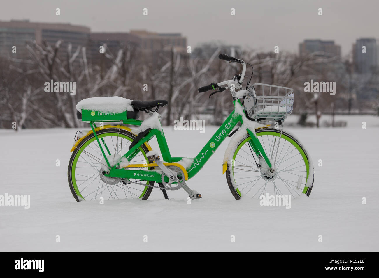 Eine dockless, Elektrofahrrad Anteil Kalk e-bike in einem verschneiten Parkplatz sitzt verlassen Stockfoto