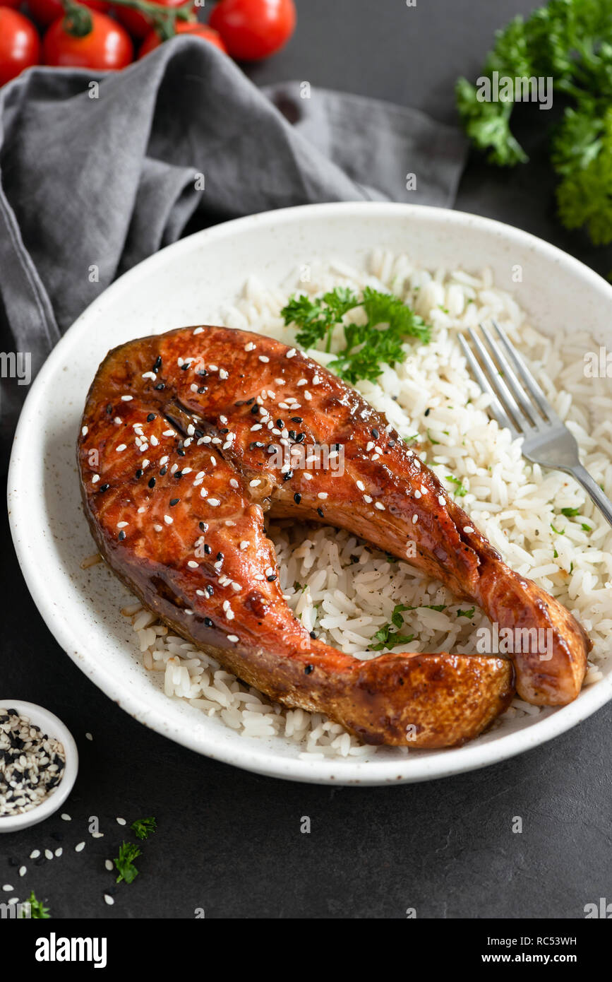 Gegrilltes Lachssteak mit Reis und sesamsamen an der Platte. Asiatische Küche Stockfoto