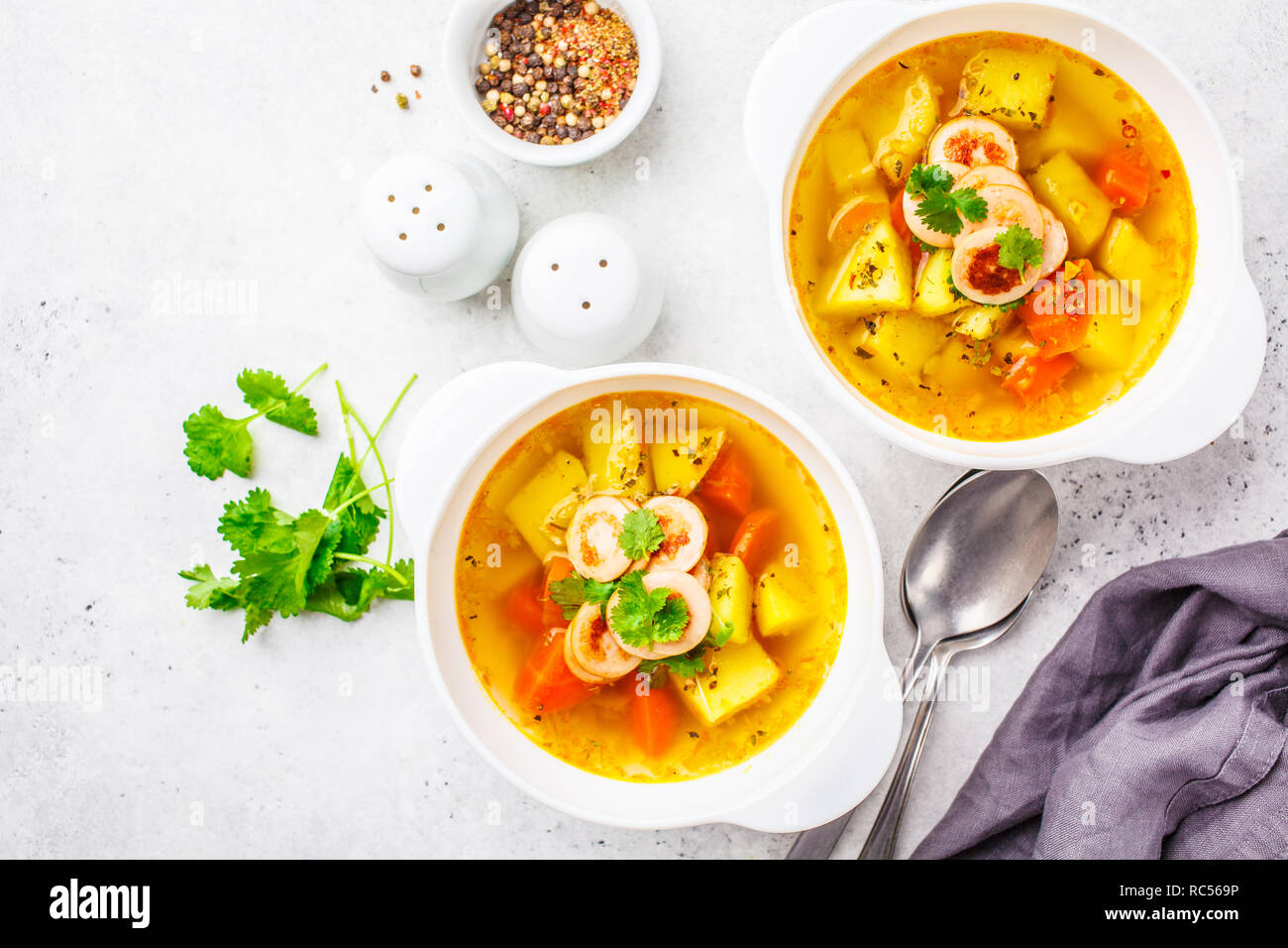 Deutsche Kartoffelsuppe mit Würstchen und Gemüse in weißen Schalen ... Deutsche Kartoffelsuppe mit Würstchen und Gemüse in weißen Schalen ...