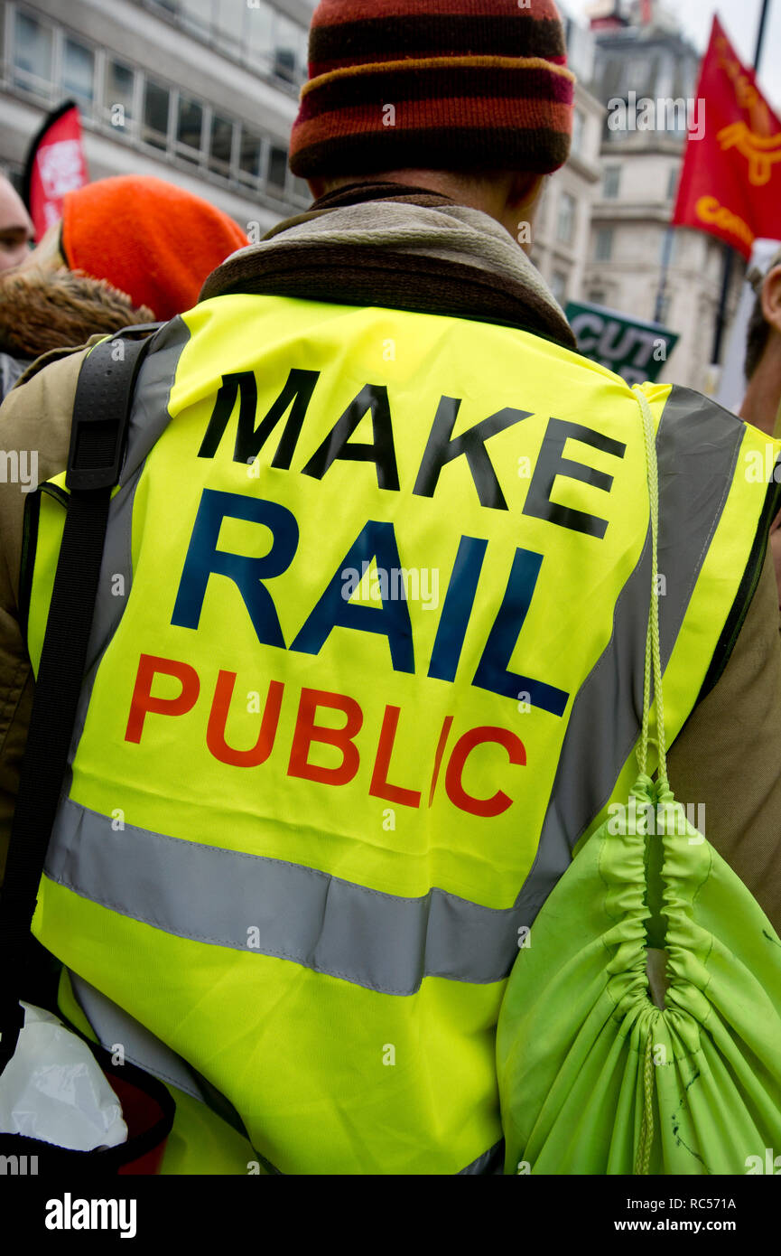 Demonstration von der Volksversammlung gegen Sparpolitik der Forderung nach einer allgemeinen Wahl. Eine Demonstrantin trägt eine gelbe Weste sagen 'Make Rail public'. Stockfoto