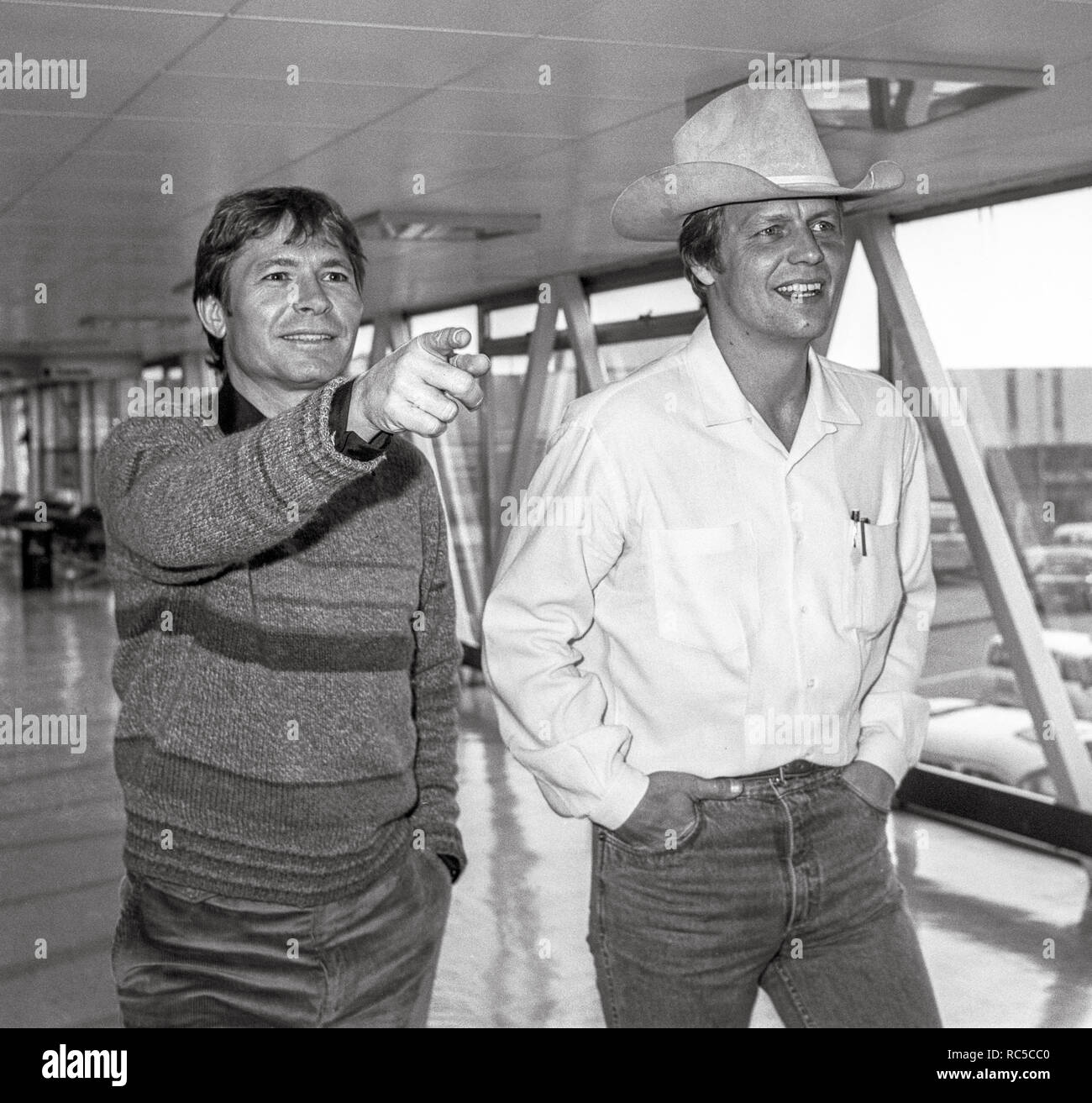 American Country Sänger John Denver und Schauspieler David Seele durch den Flughafen Heathrow reisen auf dem Weg nach Los Angeles, Februar 1984. Stockfoto
