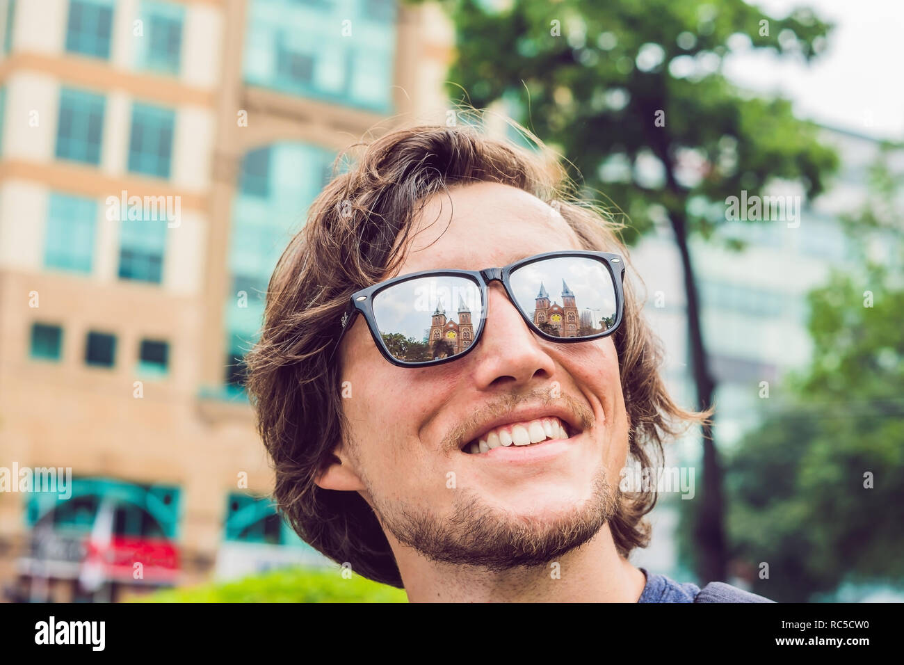 Ein Mann schaut auf Notre Dame de Saigon Kathedrale, gebaut 1883 in Ho Chi Minh City, Vietnam. Reflexion in der Brille. Stockfoto