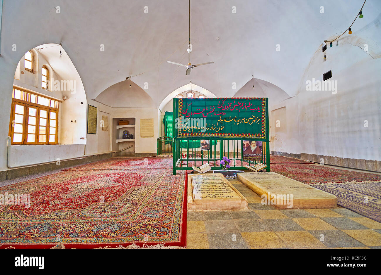 YAZD, IRAN - 18. Oktober 2017: Die bescheidene Innenraum des Mausoleums in Jameh Moschee, die grabsteine sind mit bunten Persische Teppiche umgeben, auf der O Stockfoto