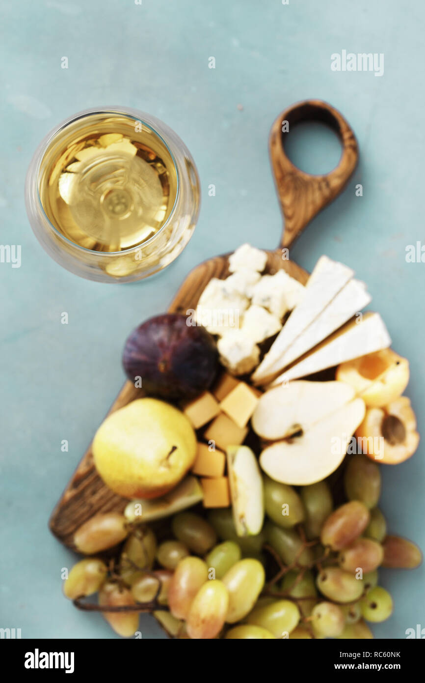 Vorspeisen Tabelle und Wein. Obst und Käse auf dem Holzbrett auf Stein Hintergrund. Wein Vorspeisen Stockfoto