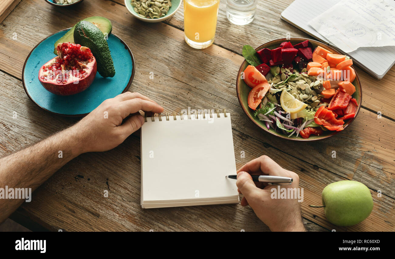 Man macht eine Liste der gesunden Lebensmittel. Gesunder Lebensstil Ernährung Food Konzept Stockfoto