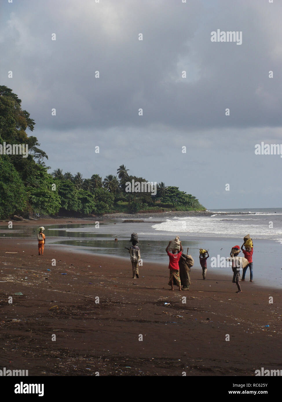 Limbe/Kamerun - November 2009: Menschen zu Fuß den Strand hinunter in der Nähe Limbe, Kamerun. Stockfoto