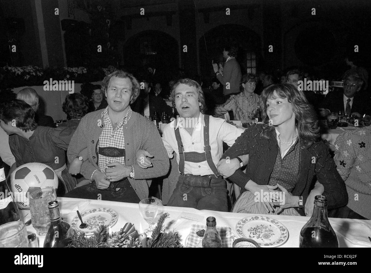 Von links: Uli Hoeneß, Wolfgang Kraus und seine Frau Lydia am Tisch Schunkeln, SW-Aufnahme, weiß celebranch des FC Bayern München in der Loewenbraeukeller, 19.12.1982, | Verwendung weltweit Stockfoto