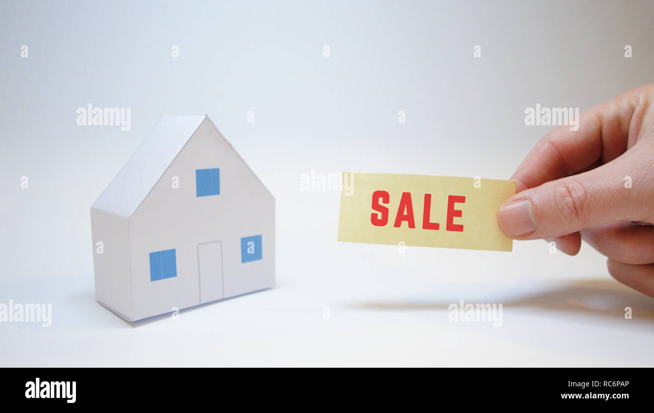 Hand zeigt ein Schild mit der Aufschrift Salz für ein Haus Verkauf Ankündigung Stockfoto