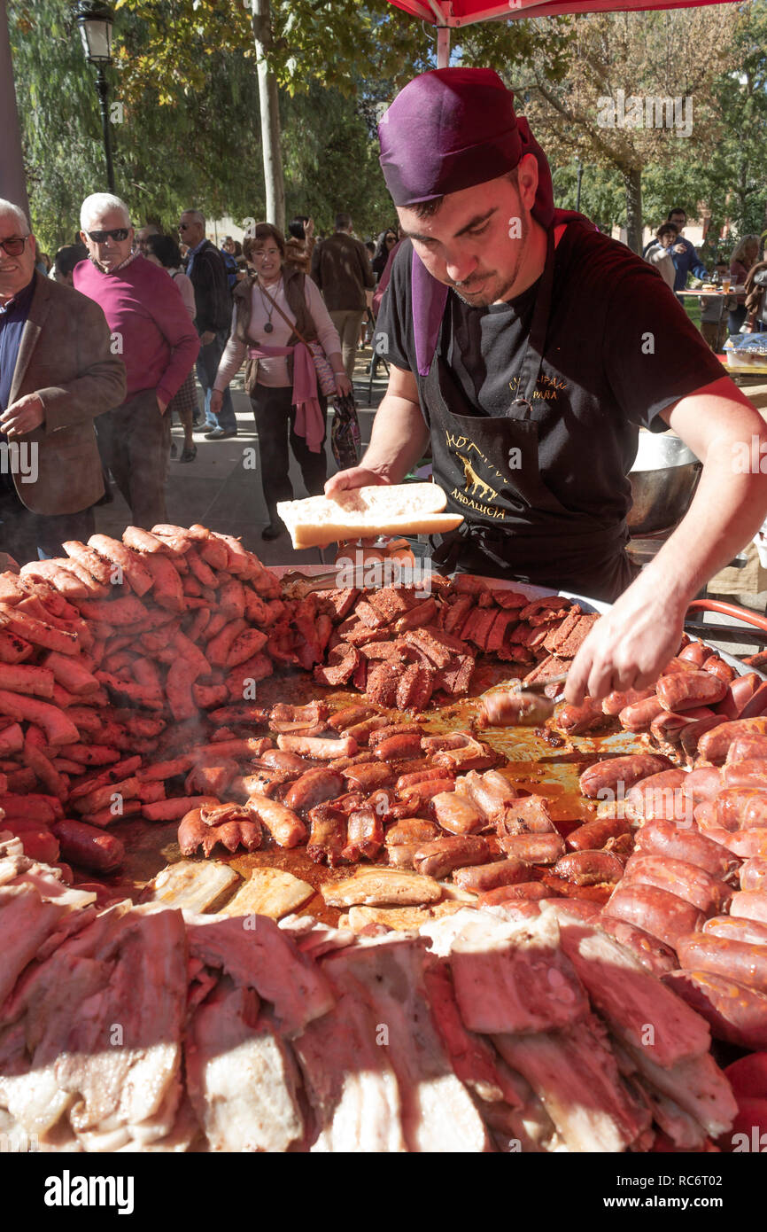 Campillos, Malaga, Spanien. Schinken und Wurstwaren Messe. Große Pfannen von Würstchen, Chorizo und anderen Schwein verwandte Produkte sind an die vielen Besucher serviert. Stockfoto