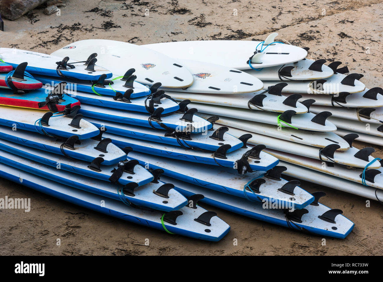 Einen großen Stapel von surfbrettern zeigt die surfoard Flossen an einem Strand. Stockfoto